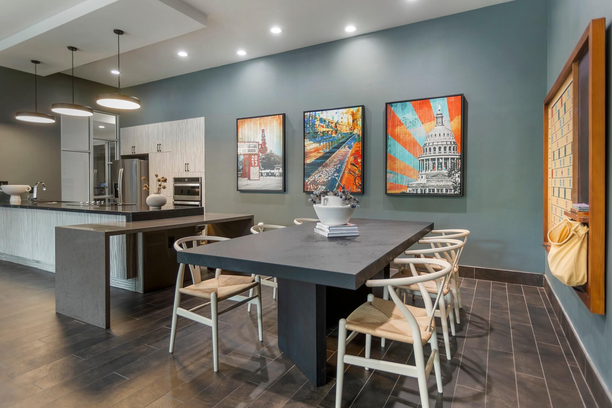 Clubhouse interior with table seating, designer lighting, wood-style flooring, bar area access, and wall decor