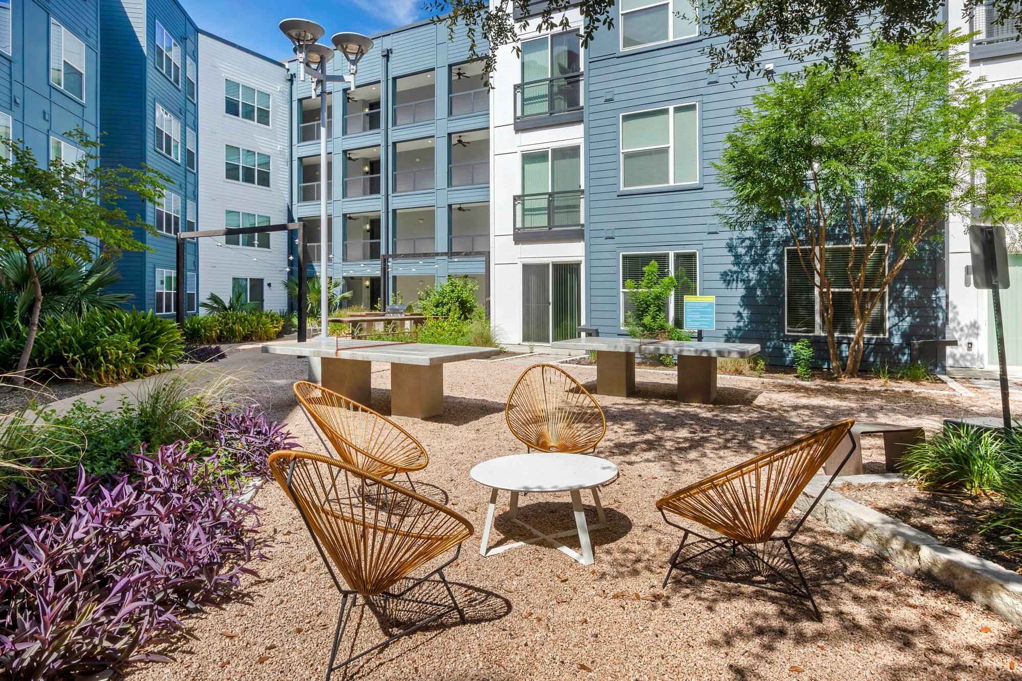 Outdoor lounge with garden landscaping, chair seating, and picnic tables